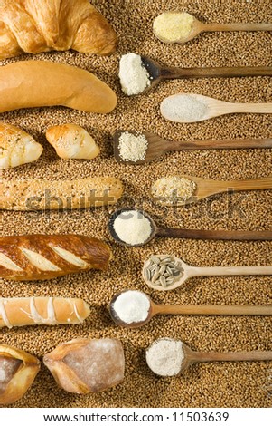 Various types of bakery with wooden spoon on wheat background