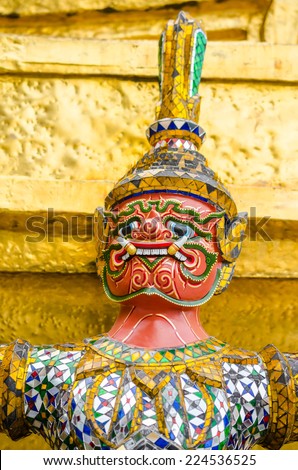 The demon statue supporting golden pagoda in the temple of the Emerald Buddha (Wat Phra Kaew) , Bangkok, Thailand.
