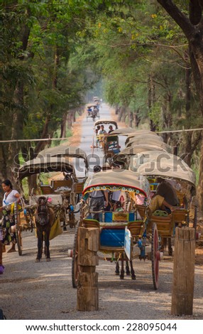 INWA, MYANMAR - MARCH 26 : Tourists on the horse carriage on March 26 , 2014 in Inwa, Myanmar. Inwa is an ancient imperial capital of successive Burmese kingdoms from the 14th to 19th centuries.