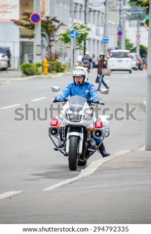 HAKODATE, JAPAN - JUNE 18, 2015 : Japanese Policeman rides the motorcycle on the road on June 18, 2015 in Hakodate city, Hokkaido, Japan.