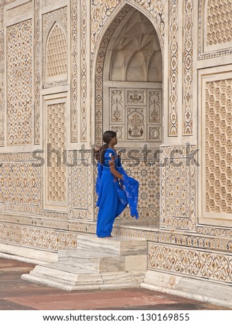 AGRA, INDIA - OCTOBER 2: India woman in blue salwar kameez entering the doorway into the ornate white marble Mughal tomb (I\'timad-ud-Daulah) on October 2, 2008 in Agra, Uttar Pradesh, India