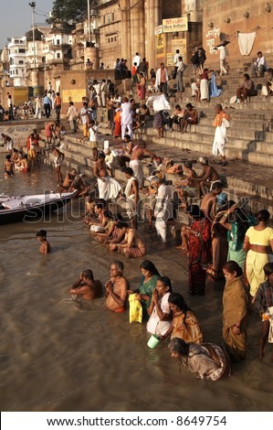 Crowds of people worshiping bathing in the sacred River Ganges at Varanasi, India
