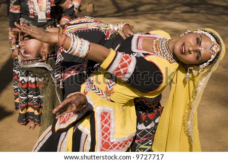 Indian kalbelia dancers in action in traditional yellow and black clothing
