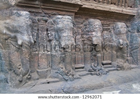 Row of elephants carved into solid rock along the base of a Hindu rock temple. Cave number 16, Ellora Caves, near Aurangabad, India. 8th Century AD