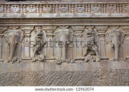 Row of elephants carved into solid rock along the base of a Hindu rock temple. Cave number 16, Ellora Caves, near Aurangabad, India. 8th Century AD