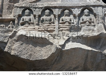 Religious figures carved out of the rock on the facade of an ancient Buddhist rock temple  (cave 26), Ajanta Caves near Aurangabad, India. 5th-6th Century AD.