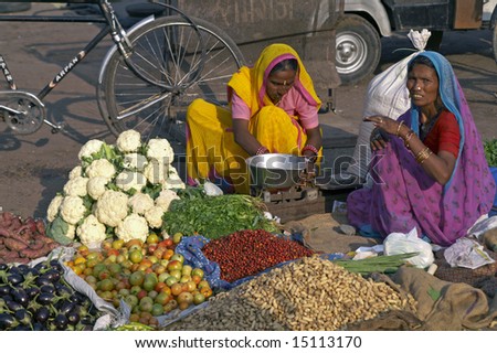 JAIPUR, INDIA - NOVEMBER 12: Unidentified Indian women in brightly colored saris selling fruit and vegetables by the side of the road. November 12, 2007 in Jaipur, Rajasthan, India.