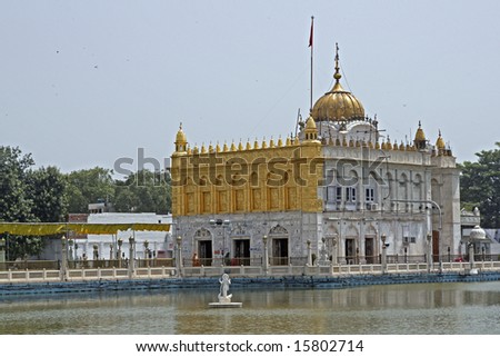 Durgiana Hindu Temple. White marble building with gold dome set in artificial lake. Amritsar, Punjab, India