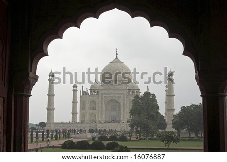 Taj Mahal. White marble tomb set on raised platform topped by large oval dome. Framed in Mughal arch. Agra, Uttar Pradesh. India