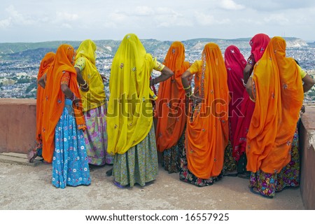 Indian women in brightly colored saris on the roof of a Rajput palace. Tiger Fort, Jaipur, Rajasthan, India
