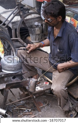 DELHI - SEPTEMBER 18: Indian man welding in the street. September 18 2006 in Old Delhi, India
