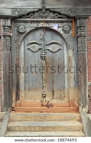 Ancient wooden door with buddhist eyes at the Hanuman Royal Palace in Durbar Square, Kathmandu, Nepal