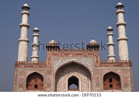 Ornate entrance to Akbar\'s Tomb. Islamic style architecture. Red sandstone building inlaid with white marble with marble minarets at each corner. Sikandra, Agra, India