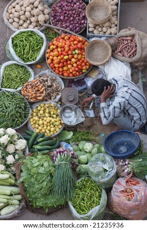 Man selling fruit and veg at a street market in Pushkar, Rajasthan, India
