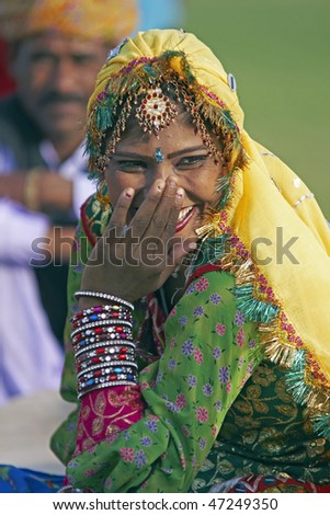 JAIPUR, INDIA - MARCH 10: Indian lady in traditional costume covering her face and laughing at the annual elephant festival on March 10, 2009 in Jaipur, Rajasthan, India.