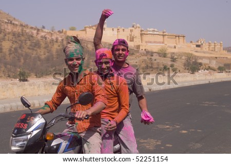 JAIPUR, INDIA - MARCH 22: Group of young Indians on a motorbike covered in colored paint from celebrating the Hindu Festival of Holi on March 22, 2008 outside Amber Fort in Jaipur, Rajasthan, India.
