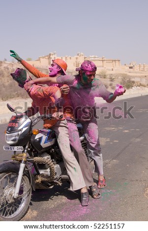 JAIPUR, INDIA - MARCH 22: Group of young Indians on a motorbike covered in colored paint from celebrating the Hindu Festival of Holi on March 22, 2008 outside Amber Fort in Jaipur, Rajasthan, India.