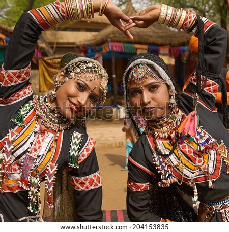 HARYANA, INDIA - FEBRUARY 12, 2009: Beautiful Kalbelia dancers in ornate black costumes trimmed with beads and sequins at the annual Sarujkund Fair near Delhi, India.