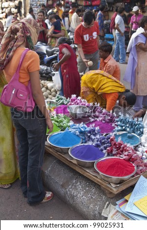 AHMADABAD, INDIA - OCTOBER 31: Woman buying colorful paint powder for the Hindu festival of Holi at a crowded market on October 31, 2007 in Ahmadabad, Gujarat, India