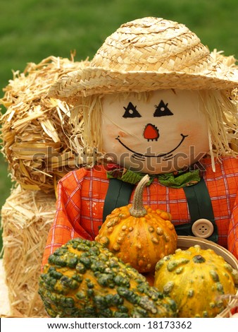 Fall holiday decoration with pumpkins and scarecrow and straw bales