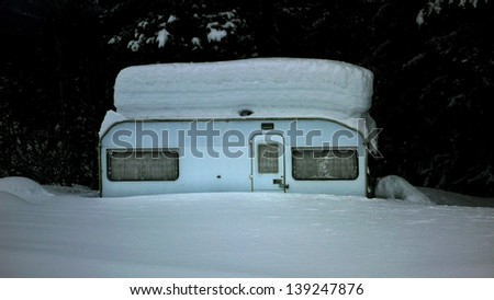 Abandoned camping wagon covered with deep snow