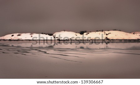 Snowy island in frozen sea