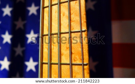 Neck of a bass guitar with US flag in the background