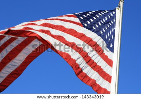 United States of America Flag Waving \'United States of America\' flag.  The flag is flying beneath a brilliant blue sky.