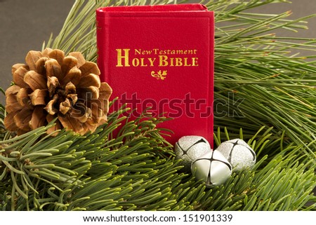 Bible and Pine Branches Small red Bible,  with a pine cone and three silver sleigh bells.  Bible, pine cones and silver bells are surrounded by fresh cut long needled pine and blue spruce branches.