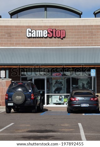 WESTMINSTER, COLORADO/U.S.A. - APRIL 15, 2012:  Game Stop retail store with customer vehicles in the parking lot.  The entrance door to Game Stop, with the Game Stop sign above.