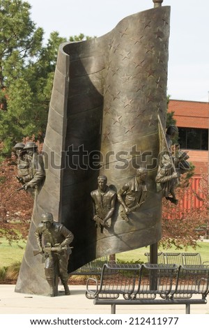 NORTHGLENN, COLORADO/U.S.A.  - MAY 13, 2014:Northglenn Veterans Memorial, bronze 23 foot tall American flag, with soldiers of all branches of the military. Created by Hai Ying Wu, to honor veterans.