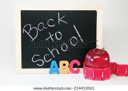 Back to School Board Black chalk board with the words \'Back to School.\'  To the right there are ABC\'s, red ruler and red apple.