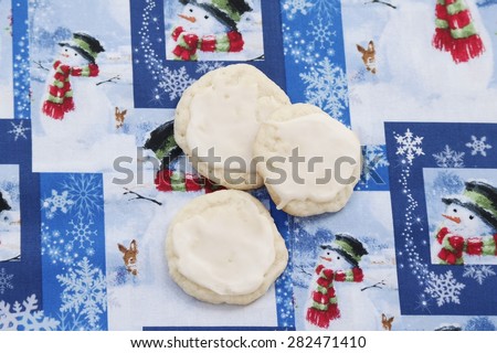 Christmas Sugar Cookies\
Three delicious sugar cookies, with a Christmas patterned background.
