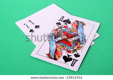 Some playing cards and lady peak from above on a green background