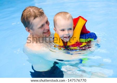 boy of 4 years learns to swim in pool with father