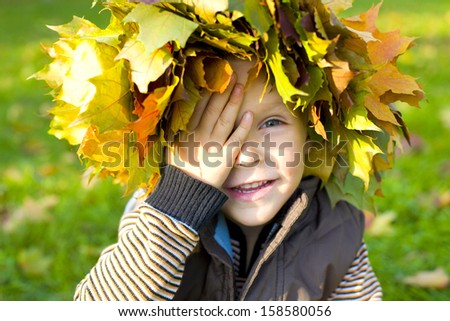 Funny little boy covered his eyes with his hand