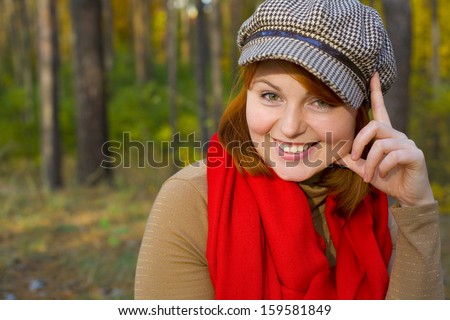 Portrait of attractive red-haired girl in cap