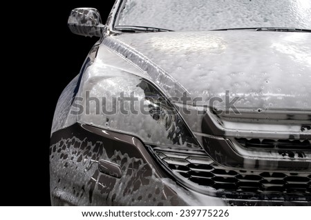 Modern car covered by foam. Car wash.