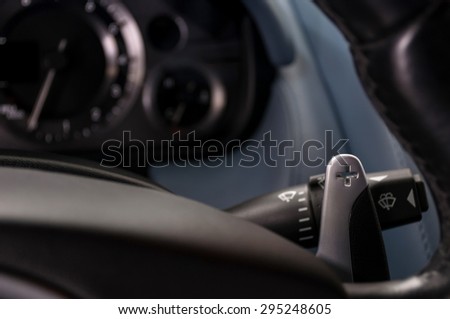 Sport car gear lever. Manual gear changing paddle on car\'s steering wheel. Interior detail.