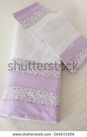 Purple dish cloth folded on white linen towel