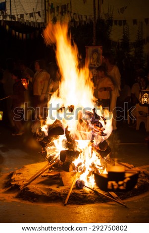 Night campfire with people surrounding on school party