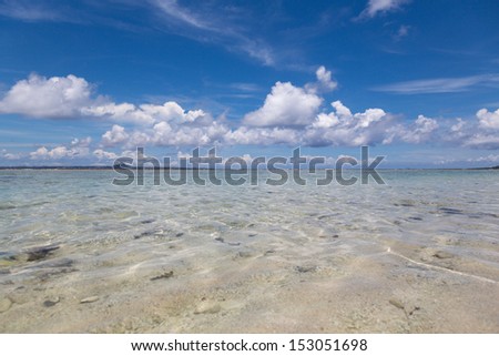 The blue sky and sea. A deep blue cloud white in the sky flows. The transparency that the sea is very high.