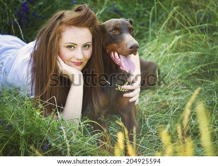 beautiful red hair women / girl with brown doberman pinscher dog hug outdoors