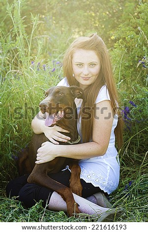 beautiful red hair women / girl with brown doberman pinscher dog hug outdoors