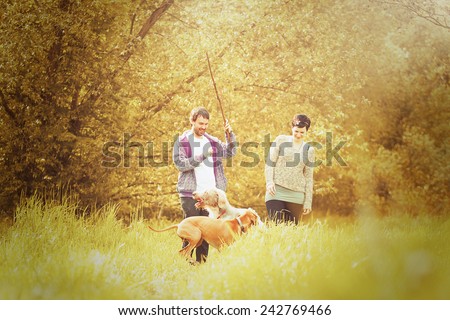 beautiful love couple man and woman on walk with dog in autumn nature