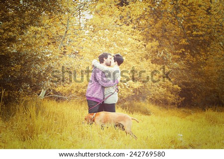 beautiful love couple man and woman on walk with dog in autumn nature