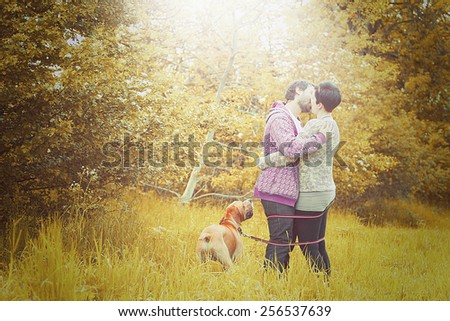 beautiful love couple man and woman on walk with dog in autumn nature