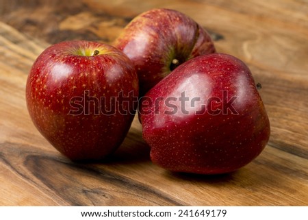 Three apples on a wooden table