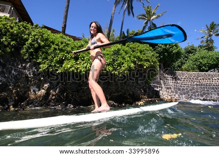 female doing stand up paddle surfing