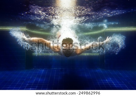 man in sunglasses underwater dives under water in the pool